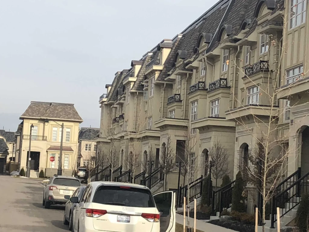 Row of townhouses with cornices, window head trim and arched entrances in a beige finish