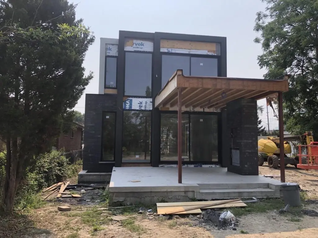 Two-storey modern house in house wrap with large windows set and a bare porch frame